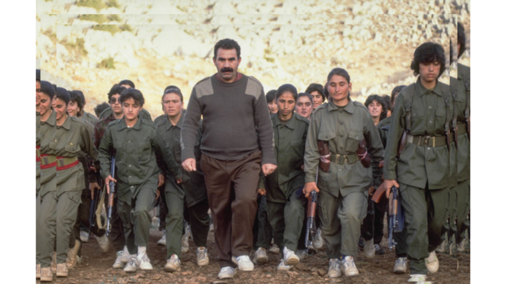 Abdullah Öcalan walking side by side with female gerilla fighters
